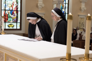 Sister Aimee Marie signs her vows on the altar.