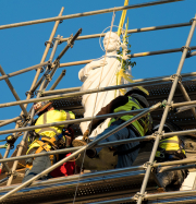 The restored statue of St. Joseph is lowered into the rebuilt niche over the 1888 wing of St. Cecilia Motherhouse.