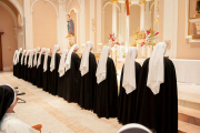 The new novices stand before the altar.