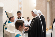 During the Mass at which the sister professes her vows, she receives the black veil from the bishop.