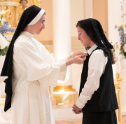 Here the prioress general gives the postulant a Dominican pin in the ceremony of her entrance.