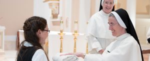 A postulant receives the habit from Mother Anna Grace