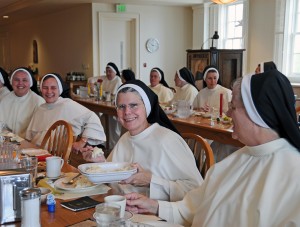 Sisters smiling while filling plate at breakfast