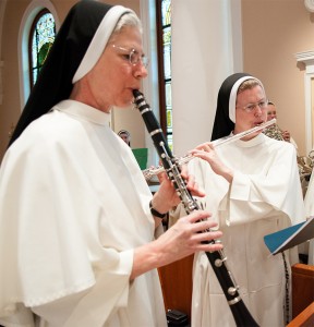 Two sisters in the chapel. One playing clarinet, one playing flute