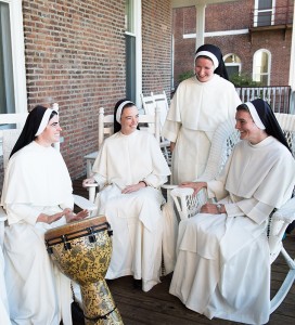 four Dominican sisters on back porch playing music